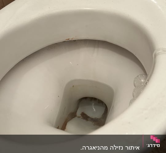 תקריב של אסלת שירותים עם סימני נזילת מים ולכלוך